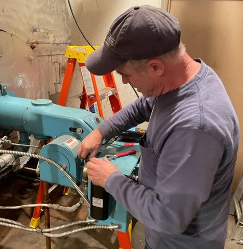 A boiler maintenance man inspecting a boiler part.